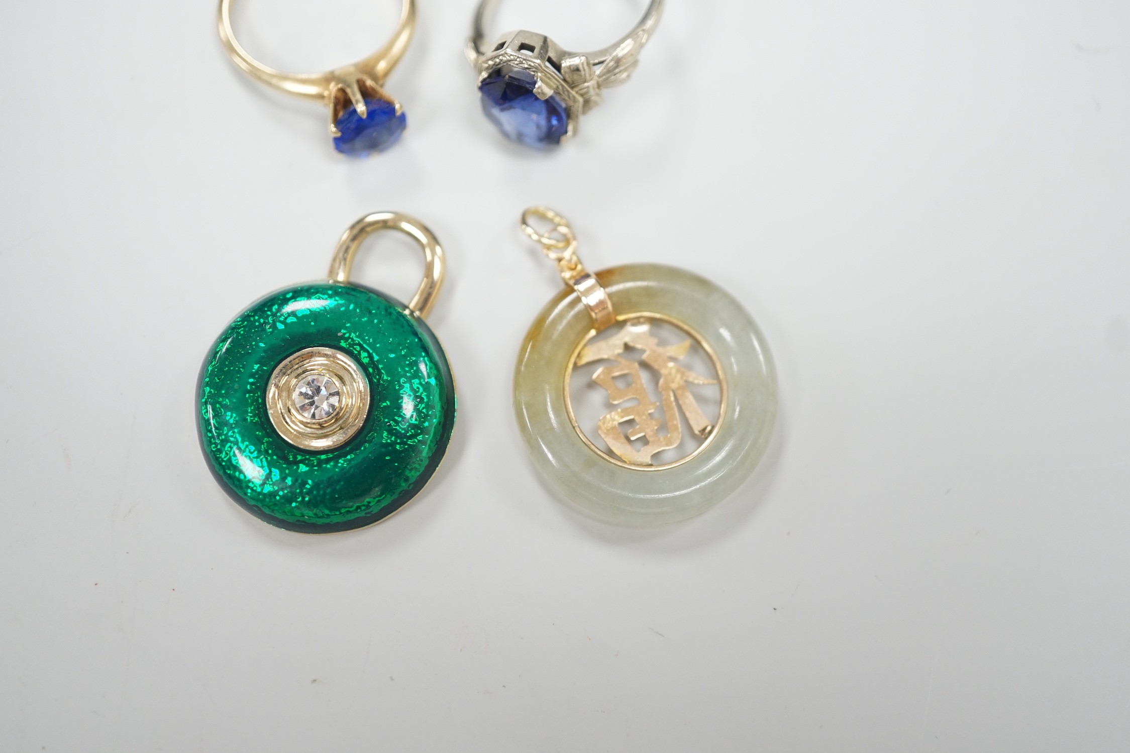 A 14k white metal and oval cut synthetic sapphire ring, a yellow metal and blue paste ring, a 585 yellow metal and jadeite pendant and a costume pendant.